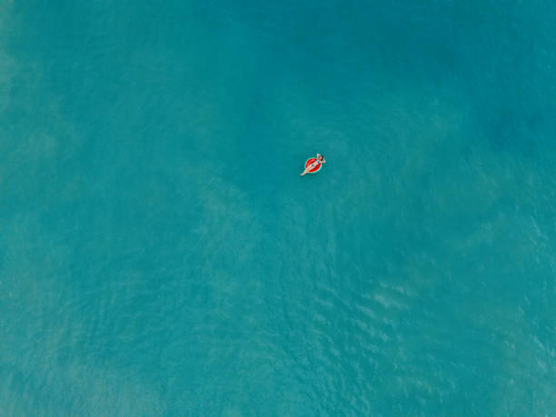 istock Woman Relaxing on Inflatable in Vast Blue Ocean 2187765848
