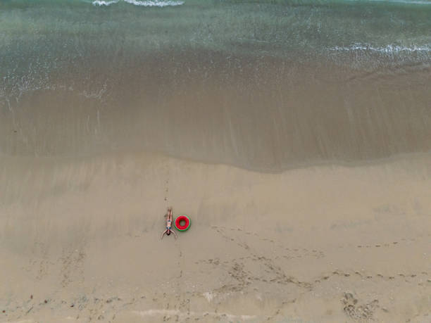 istock Woman Relaxing on Sandy Beach with Inflatable Ring 2187765906