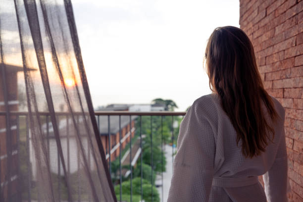 istock Woman in Robe Watching Sunset from Balcony 2187766871