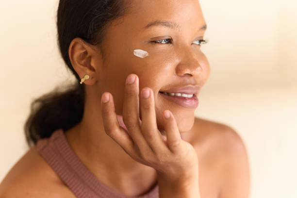 istock Smiling Woman Applying Moisturizing Face Cream for Natural Skincare Routine 2187771675