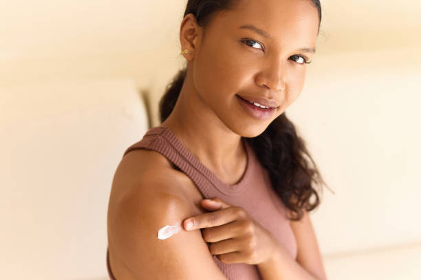 istock Body Care Routine: Woman Applying Moisturizer to Her Arm With a Smile 2187771692
