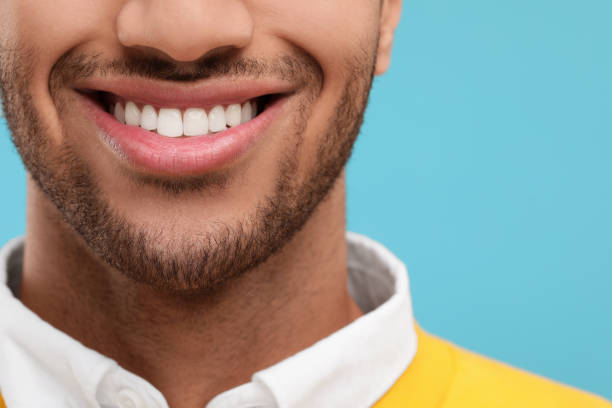 istock Smiling man with healthy clean teeth on light blue background, closeup 2187774145