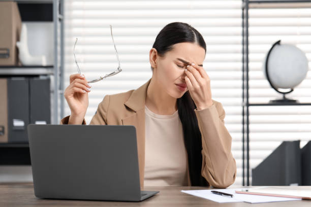 istock Woman suffering from headache at workplace in office 2187774164