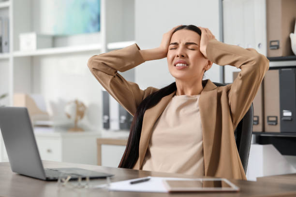 istock Woman suffering from headache at workplace in office 2187774203