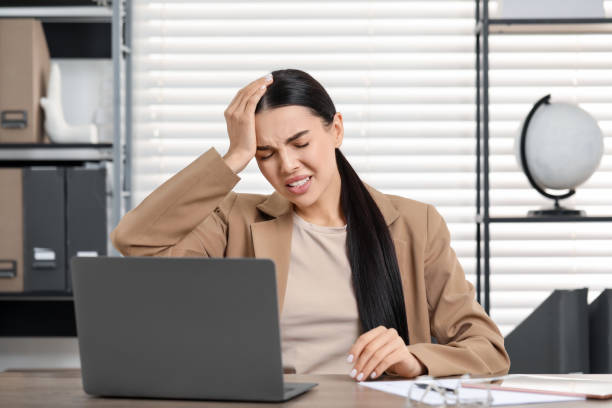istock Woman suffering from headache at workplace in office 2187774232