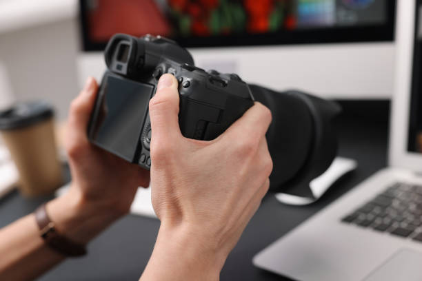 istock Professional photographer with digital camera at table indoors, closeup 2187774841