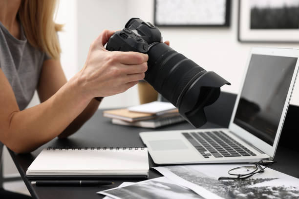 istock Professional photographer with digital camera at table in office, closeup 2187775058