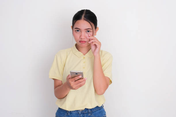 istock A woman showing sad expression while holding her mobile phone 2187777013