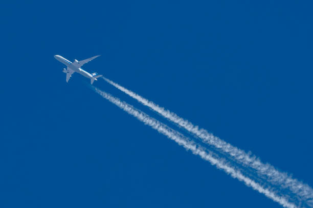 istock Commercial airplane with jet stream overhead view with vapour trail. 2187777196