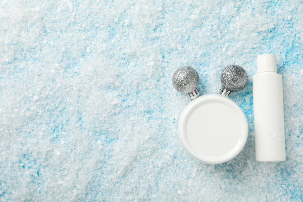 istock Cosmetics bottle and jar, balls and snow on blue background, space for text 2187780723