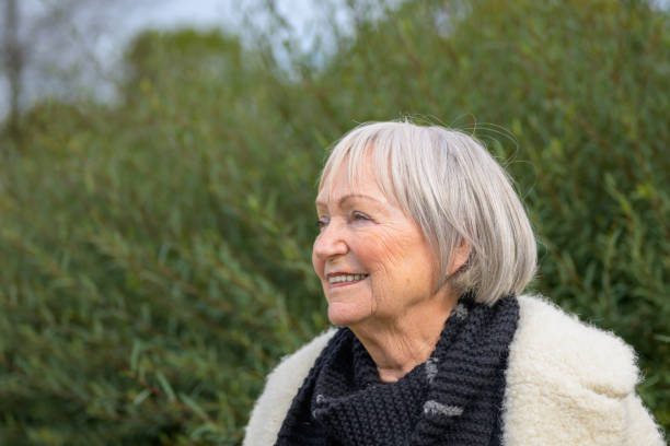 istock Elderly Woman Smiling in a Green Natural Setting 2187783696