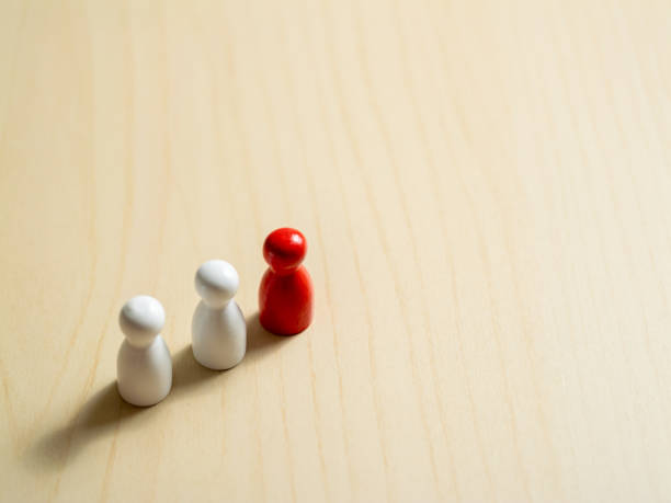 istock Leadership and team dynamics the red pawn among white pawns in a studio setting 2187787358