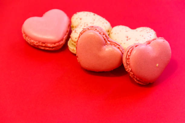 istock Sweet heart shaped macaroons on red background. Valentine Day concept 2187789978