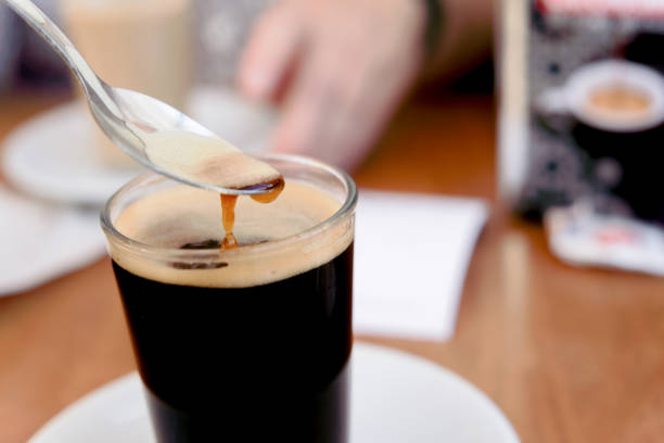 istock glass of black coffee stirring with a teaspoon 2187790676