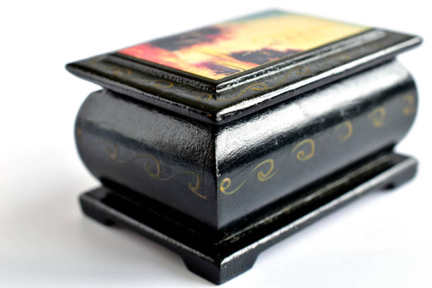 A box made of black wood with a pattern on the lid stands on a white background.