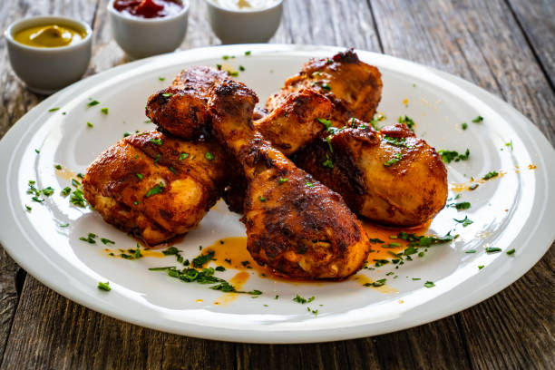 istock Barbecued chicken drumsticks on white plate on wooden table 2187791611