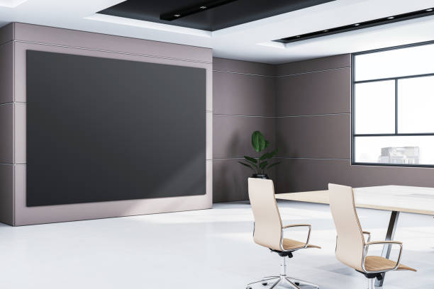 istock Modern conference room interior with large black display, table, and chairs, featuring window view and minimalist design. 3D Rendering 2187792589