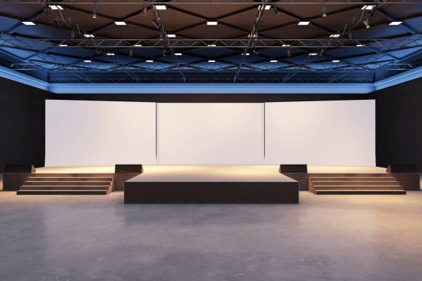 istock Modern spacious stage with blank white screens and spotlight in dark exhibition hall. 3D Rendering 2187792652