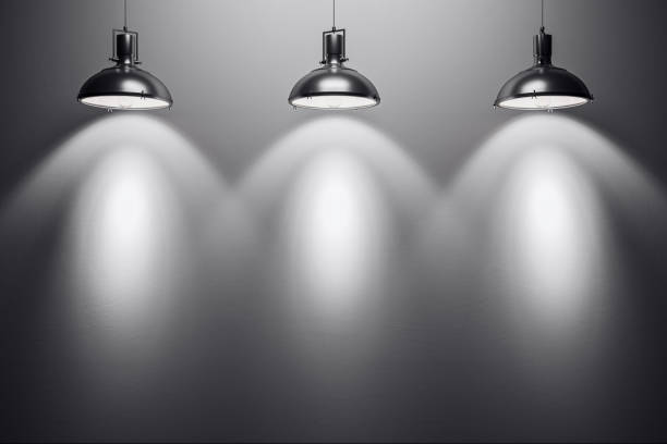 istock Three spotlight lamps illuminating a blank wall, creating a modern interior backdrop for design, gallery, or exhibition presentations. 3D Rendering 2187792755