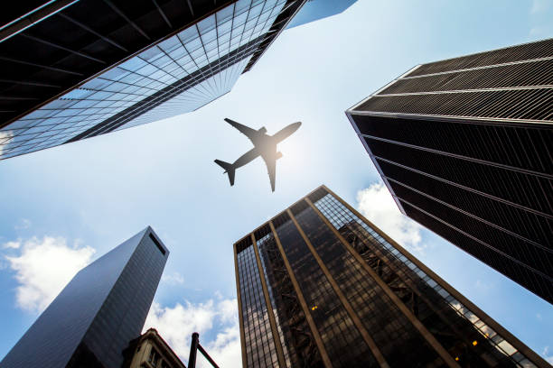 istock Airplane flying over urban skyscrapers with a clear sky background. 2187792804