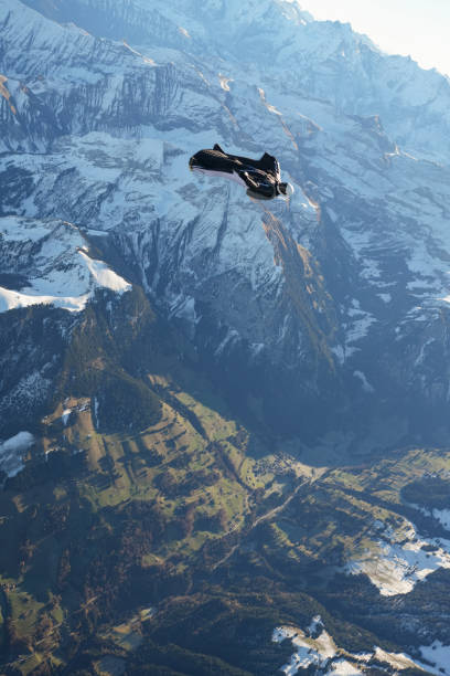 istock Wingsuit flier soars on his back above snowcapped mountains 2187796936