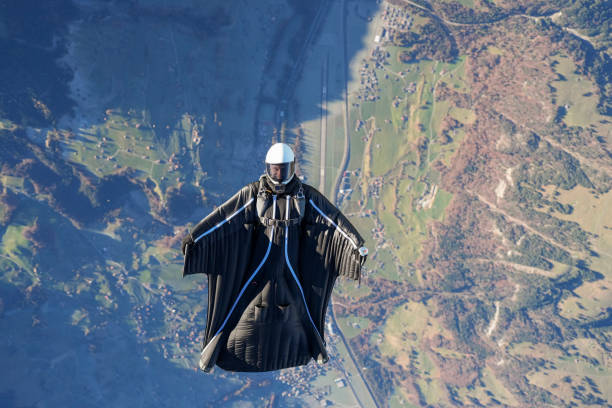 istock Wingsuit flier soars on his back above snowcapped mountains 2187796943