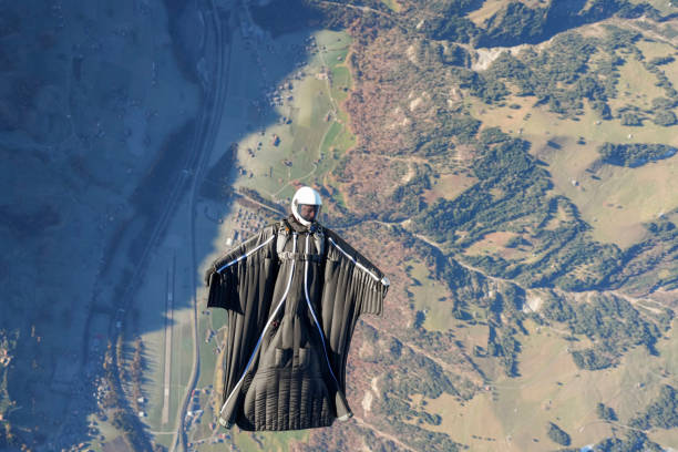 istock Wingsuit flier soars on his back above snowcapped mountains 2187797118