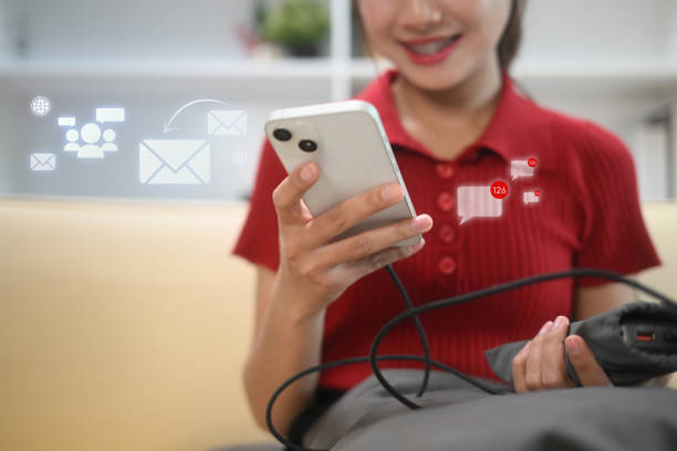 istock Cheerful young woman checking notifications and messages on smartphone 2187797687