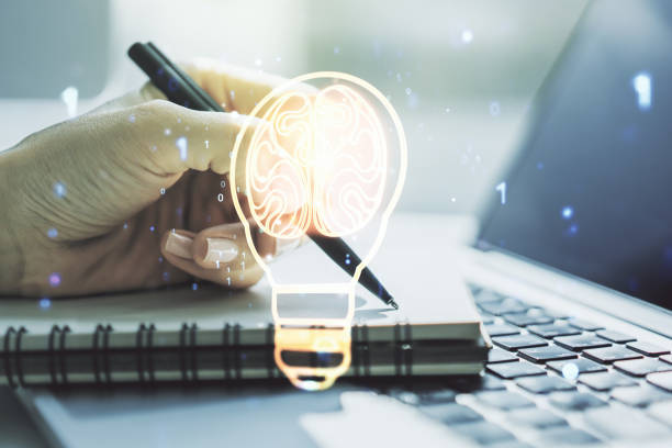 Creative idea concept with light bulb and human brain illustration and with hand writing in notebook on background with laptop. Neural networks and machine learning concept. Multiexposure