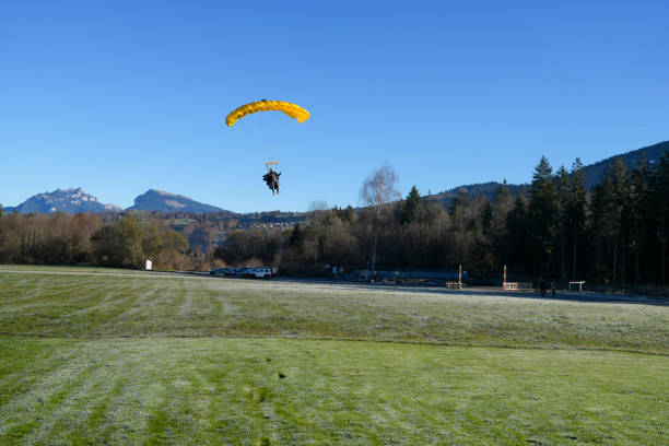 istock Parasailer comes in for landing, through blue skies 2187798180