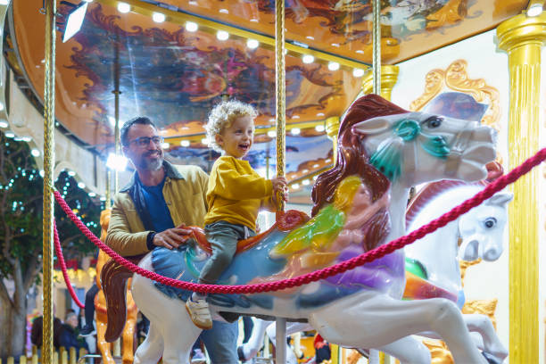 istock Father and son enjoying carousel ride at amusement park 2187800263