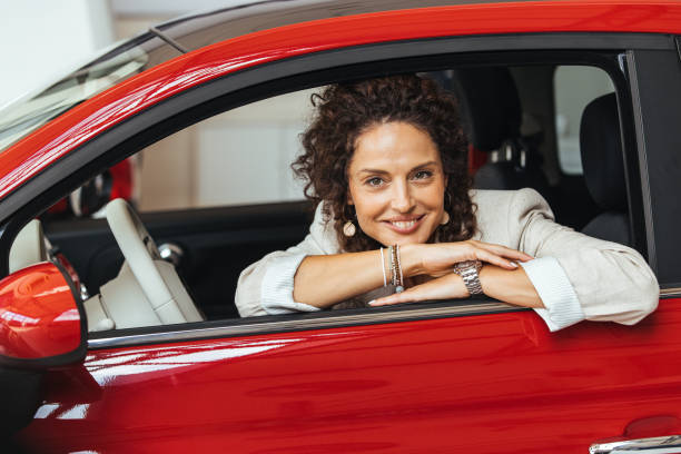 Confident Woman Smiling in Red Car Interior