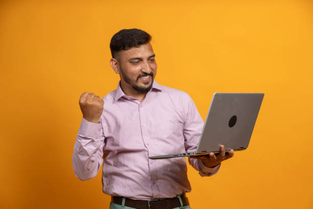 istock Overjoyed man with Laptop in hand celebrating on isolated background 2187804604