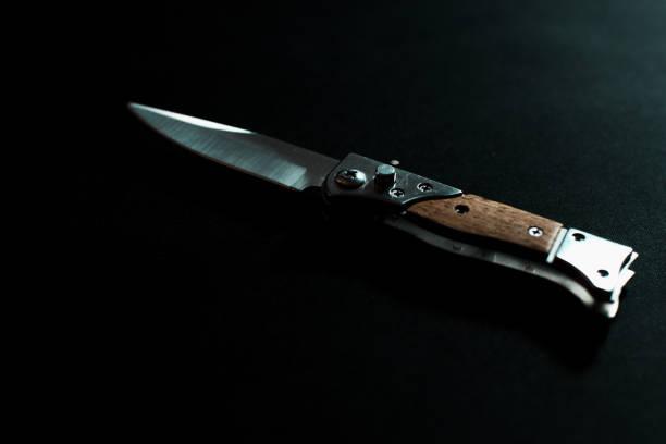 istock Folding knife with wooden handle on dark background 2187806001