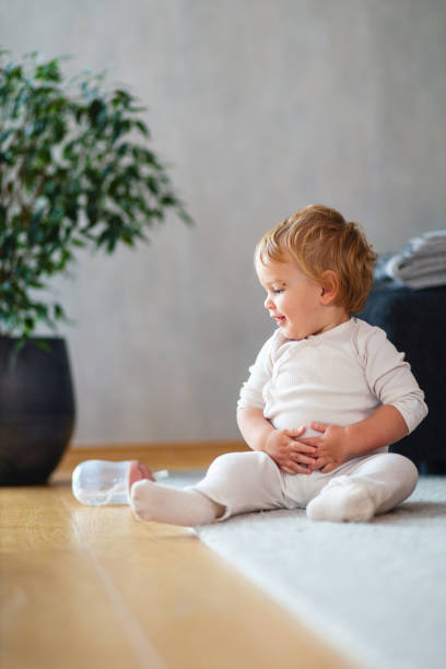 istock Smiling Baby in White Outfit Sitting Indoors 2187806298
