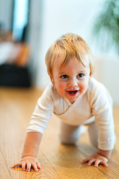 istock Adorable Baby Crawling on Wooden Floor 2187806348
