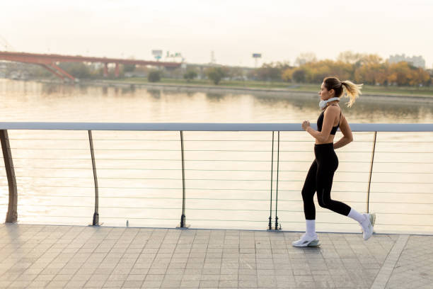 istock Early morning jogger enjoys a brisk run along a scenic waterfront pathway at sunrise in a vibrant urban park setting 2187806854