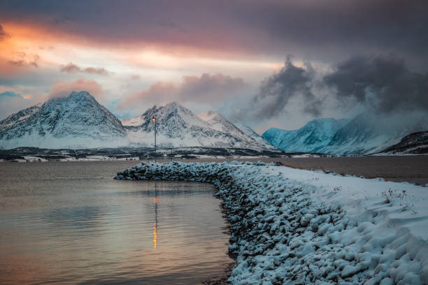 Breivikeidet ferjekai (ferry quay) in Troms, Northern Norway. Fjord, mountain and sunset sky