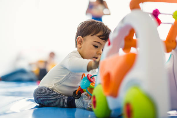 A young child playing with a colorful toy car in a bright, playful environment