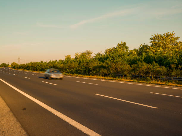Car driving fast down a highway with log tire skid marks.