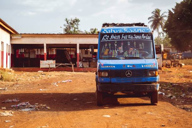Abidjan, Ivory Coast – November 05, 2024: A blue Mercedes-Benz minibus parked on a dirt road