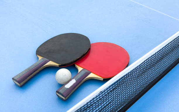 istock tennis rackets for playing ping pong on blue table, ping pong concept 2187810328