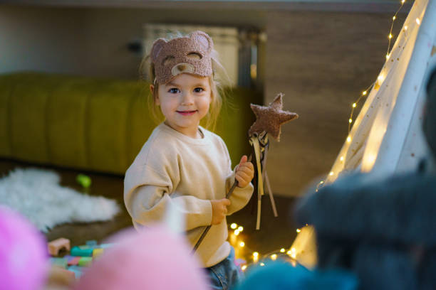 Cute little girl in costume playing whit toys at home