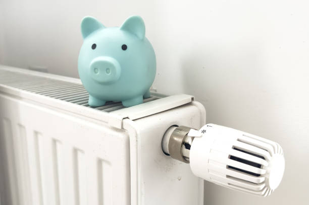 istock Piggy bank on radiator. Saving heating in winter 2187810710
