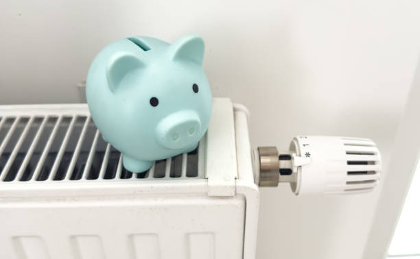 istock Piggy bank on radiator. Saving heating in winter 2187811039
