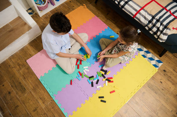 istock Two children playing with colorful blocks on a foam mat indoors 2187811955