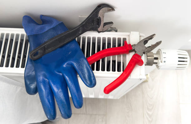 istock heating system installation and maintenance service. plumber installing radiator 2187812725