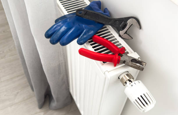 istock heating system installation and maintenance service. plumber installing radiator 2187812760