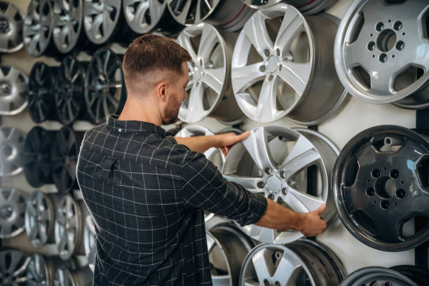 istock Choosing the right disk. Man worker is maintenance station with tires, wheels 2187817982