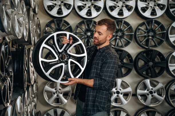 istock Brand new disk. Man worker is maintenance station with tires, wheels 2187818078